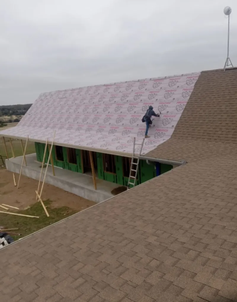 Worker preparing underlayment for a metal roof installation in Bay St. Louis